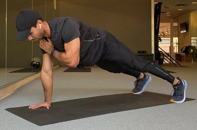 Plank chạm vai giúp tăng cường sức mạnh cơ vai, bắp tay và siết chặt cơ bụng hiệu quả.